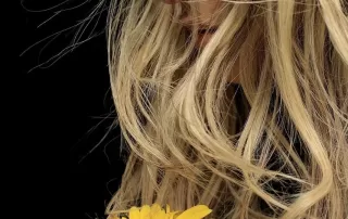 Woman holding a sunflower, symbolizing hope and holistic healing from trauma.
