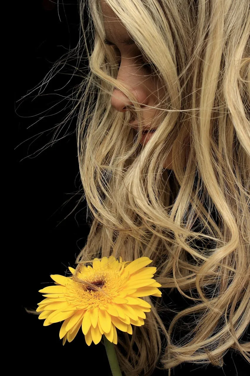 Woman holding a sunflower, symbolizing hope and holistic healing from trauma.